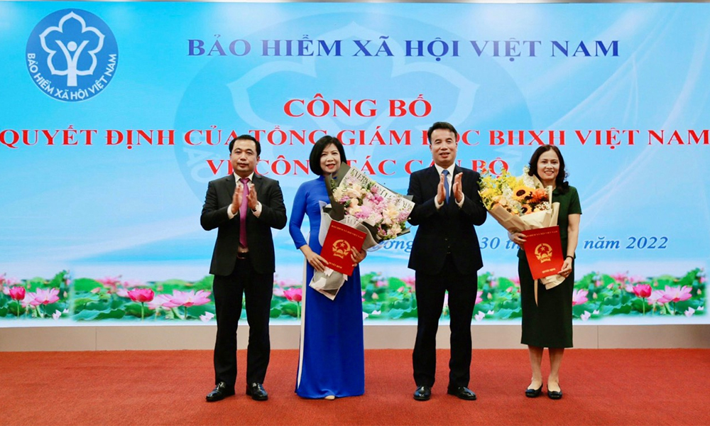 Trao Quyết định và tặng hoa cho bà Đoàn Thị Trinh và bà Trần Thị Hương. Ảnh: baohiemxahoi.gov.vn