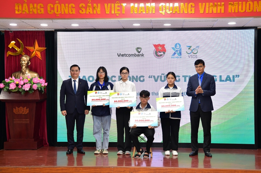 Đ/c Bùi Quang Huy - Ủy viên dự khuyết BCH Trung ương Đảng, Bí thư thứ nhất BCH Trung ương Đoàn (ngoài cùng bên phải) và đ/c Nguyễn Thanh Tùng – Phó Bí thư Đảng ủy, thành viên HĐQT, Tổng giám đốc Vietcombank (ngoài cùng bên trái) trao học bổng cho các bạn học sinh, sinh viên có hoàn cảnh khó khăn