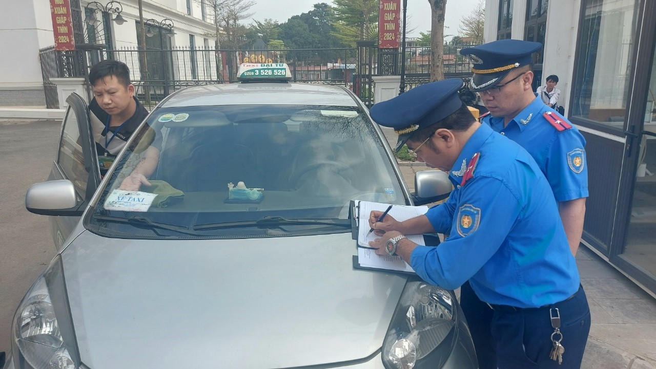 Kiểm tra việc niêm yết các thông tin và các điều kiện an toàn trên xe taxi. Ảnh: Tiến Dũng