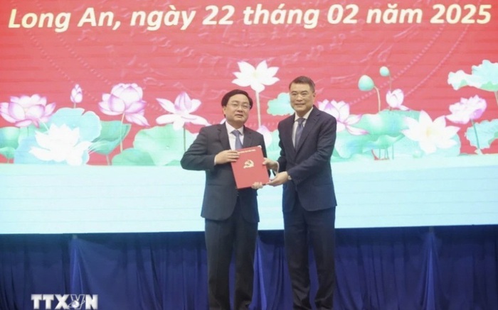 Đồng chí Lê Minh Hưng (phải) - Ủy viên Bộ Chính trị, Bí thư Trung ương Đảng, Trưởng Ban Tổ chức Trung ương - trao Quyết định của Bộ Chính trị cho đồng chí Nguyễn Văn Quyết. (Ảnh: Thanh Bình/TTXVN)